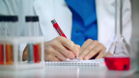Lab-researcher-writing-research-report.-Medical-student-writing-clinical-data
